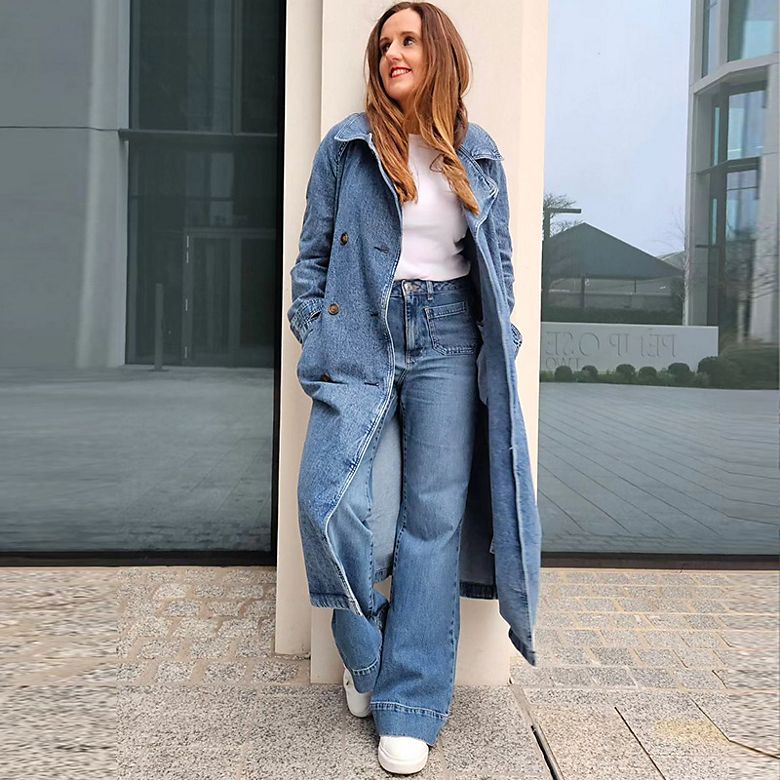 M&S Insider Michell wearing blue denim trench coat, white T-shirt and blue flared jeans. Shop women’s new-in 