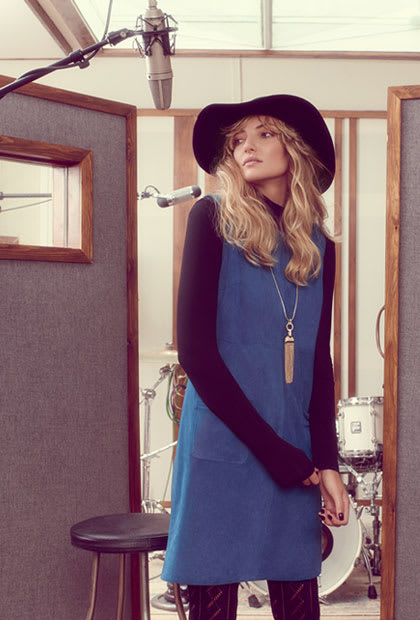 Model wears leather trousers and faux-fur coat
Model wears blue shift dress, roll neck and wide-brimmed hat