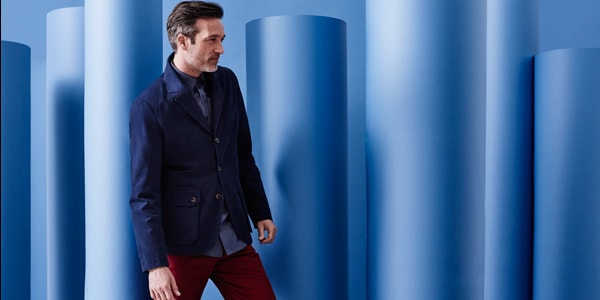 Man wearing navy blazer, blue shirt and red trousers